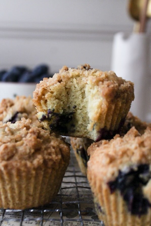 close up of a muffin with a bite missing on a stack of two muffins