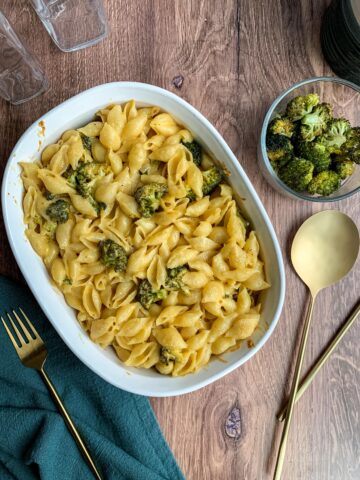 flat image of a roasted broccoli mac and cheese with broccoli and spoons