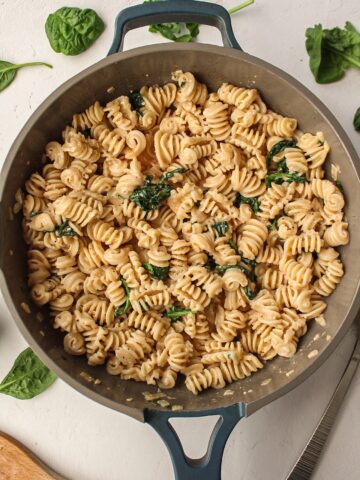 pasta with spinach in a frying pan