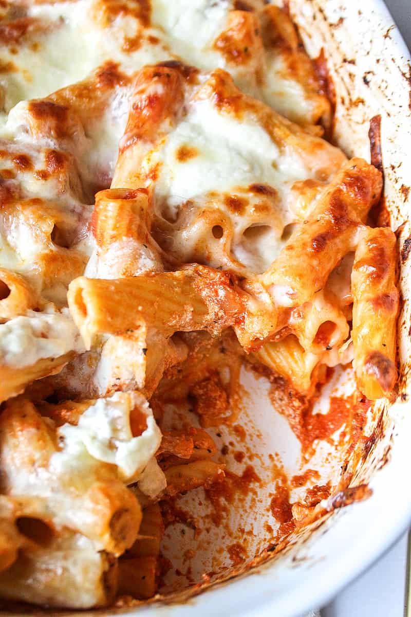 a close up shot of baked ziti in a casserole dish