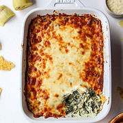a dish of spinach dip with some dip scooped out