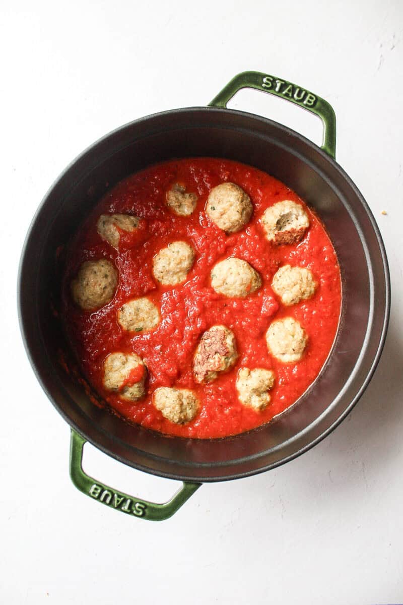 italian chicken meatballs in a large pot of sauce