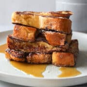 a stack of french toast sticks on a plate with syrup.