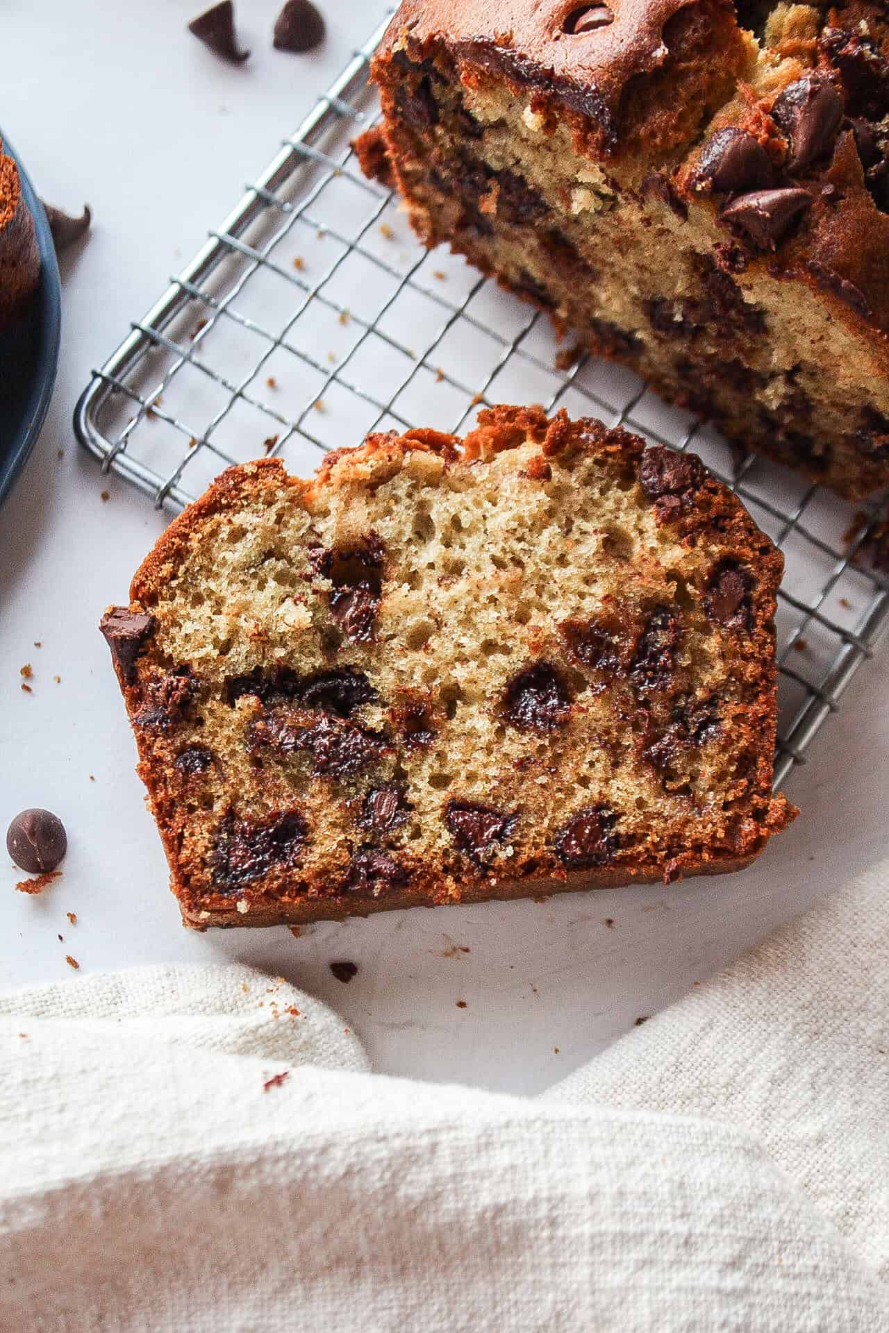 one slice of chocolate chip banana bread on a cooling rack.