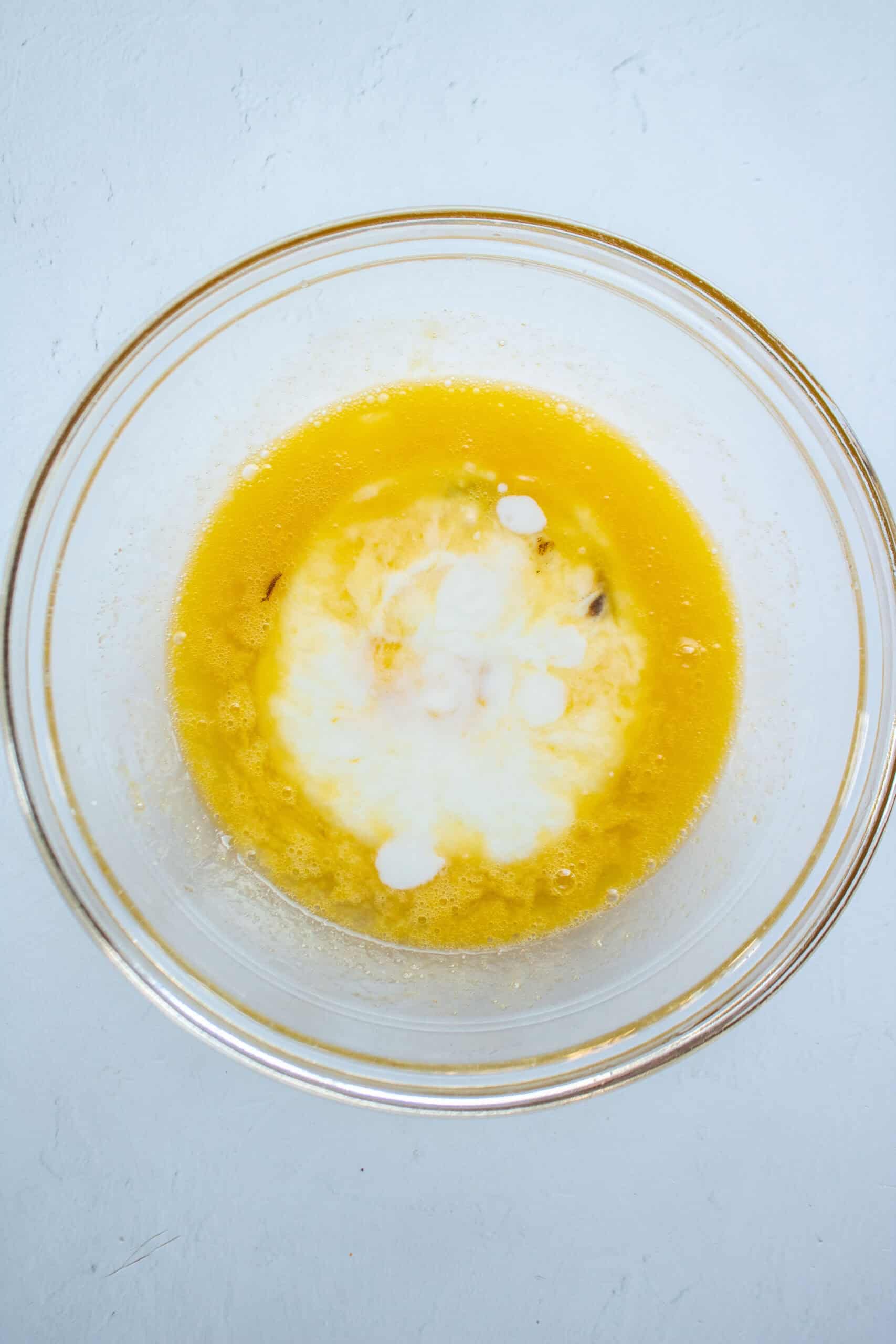 Wet ingredients of buttermilk, egg, sugar, oil, and vanilla extract in a large mixing bowl.