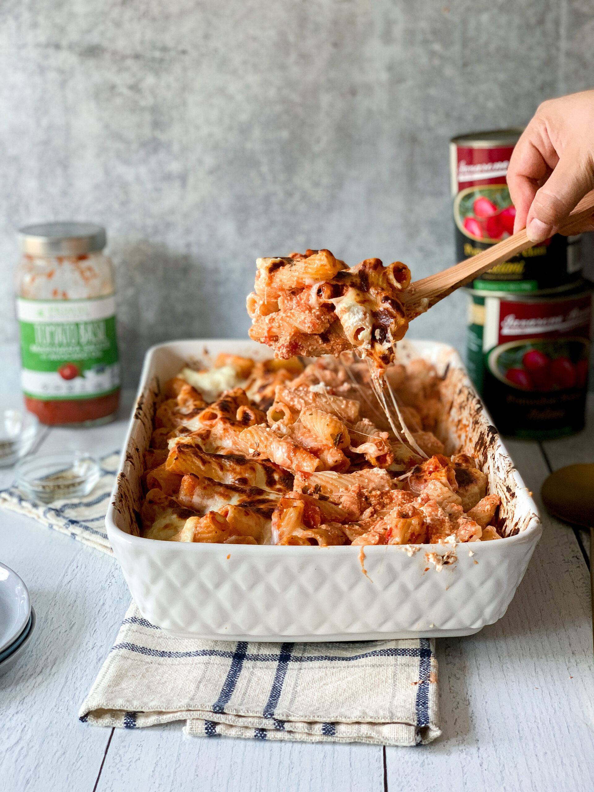 baked ziti in a spoon with a cheese pull out of a casserole dish