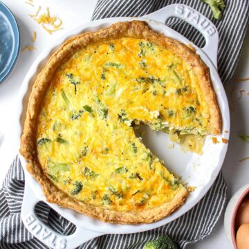 picture of a broccoli cheddar quiche with a slice cut out