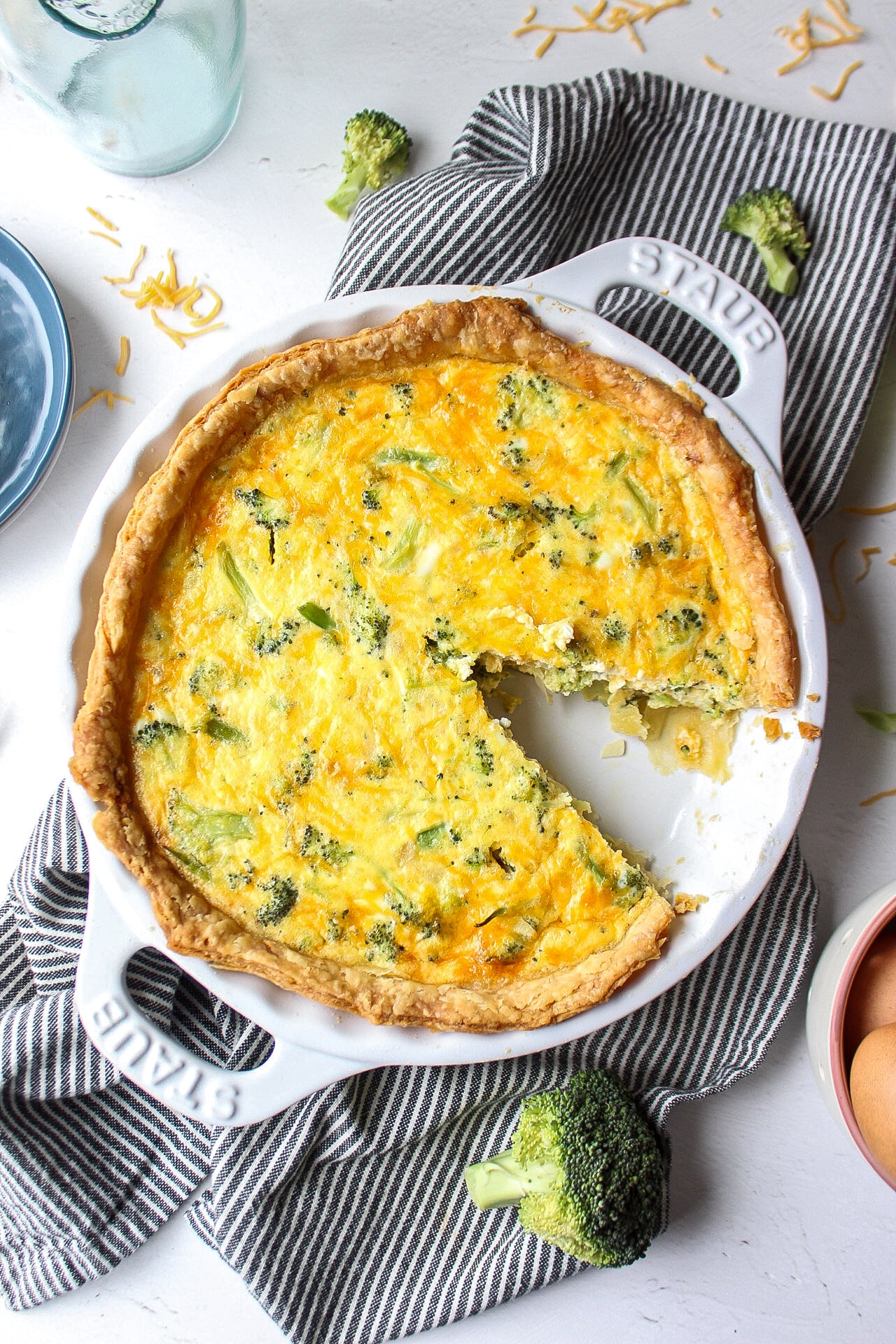 picture of a broccoli cheddar quiche with a slice cut out