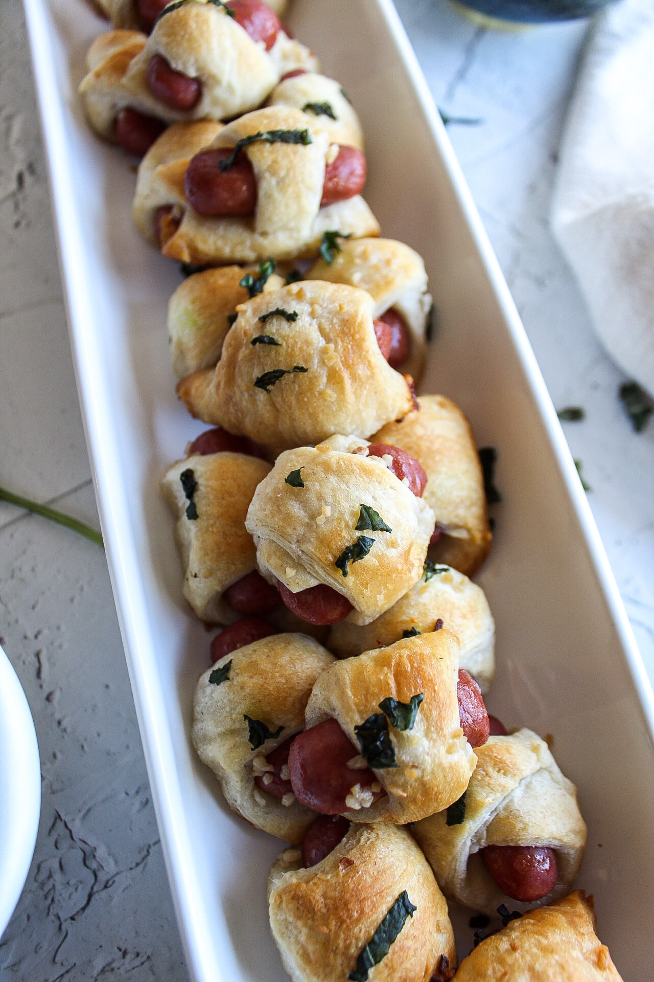 close up of pigs in a blanket in a serving dish