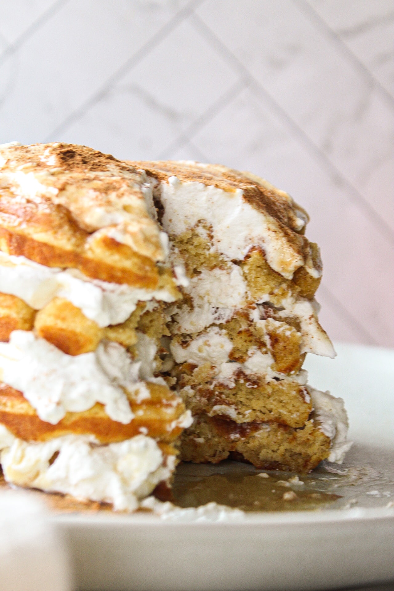 inside close up of a stack of pumpkin waffles with whipped cream in between