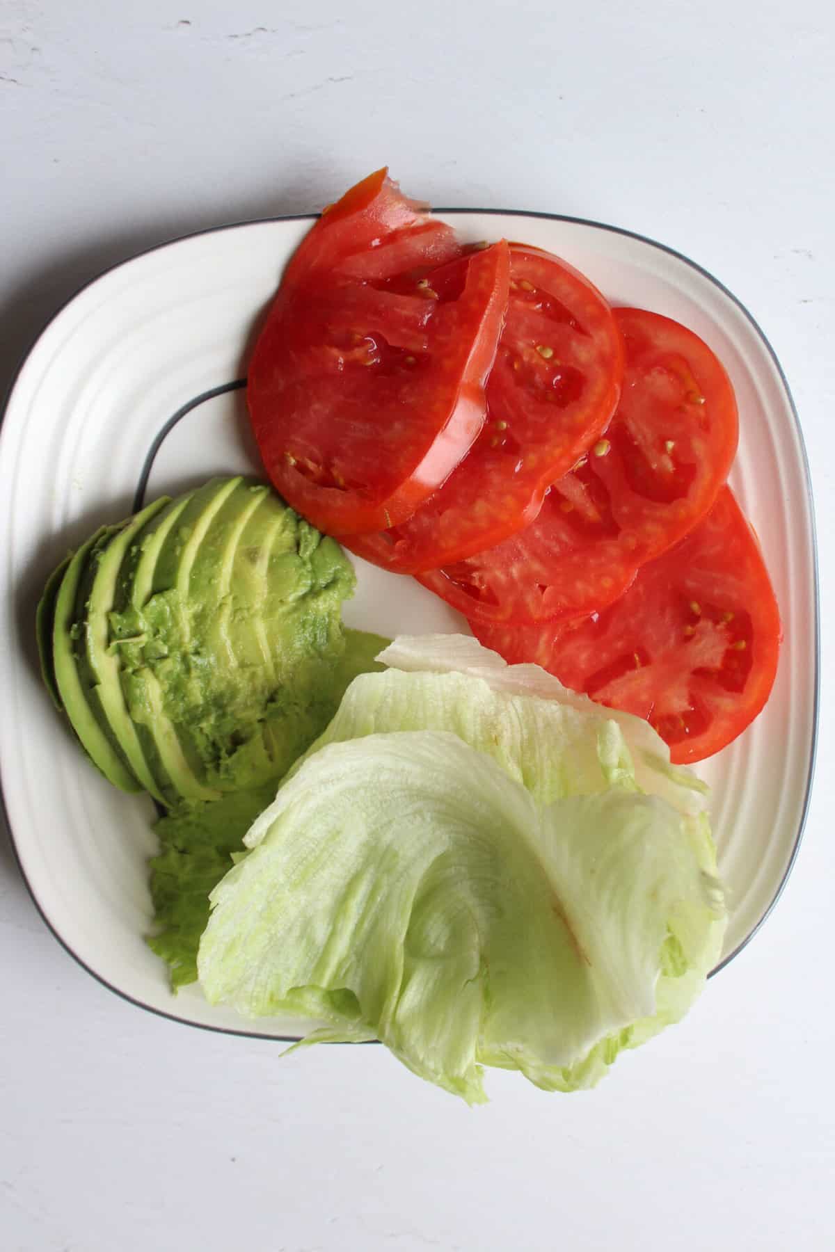 lettuce, avocado, and tomato on a plate