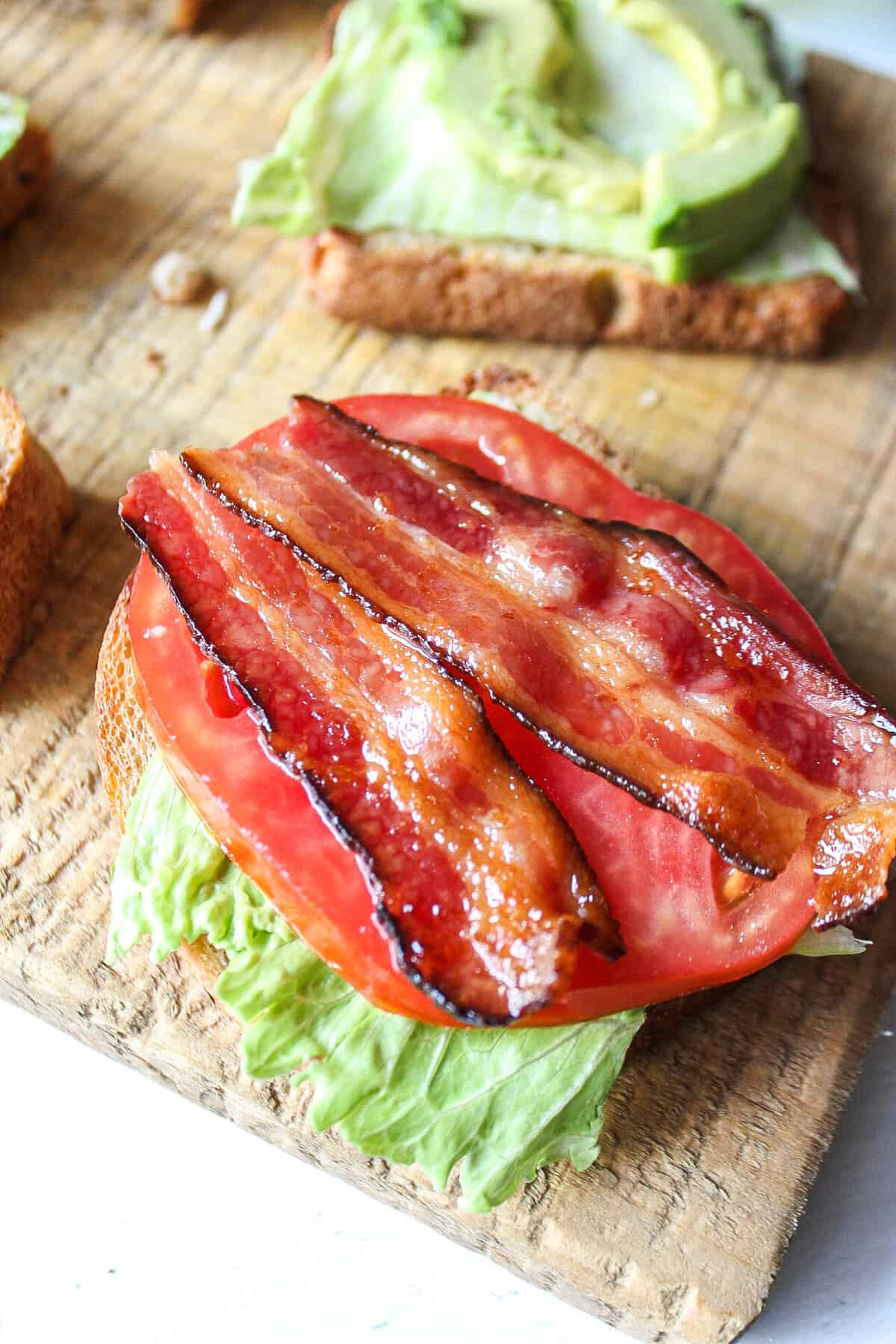 bacon on top of tomato and lettuce