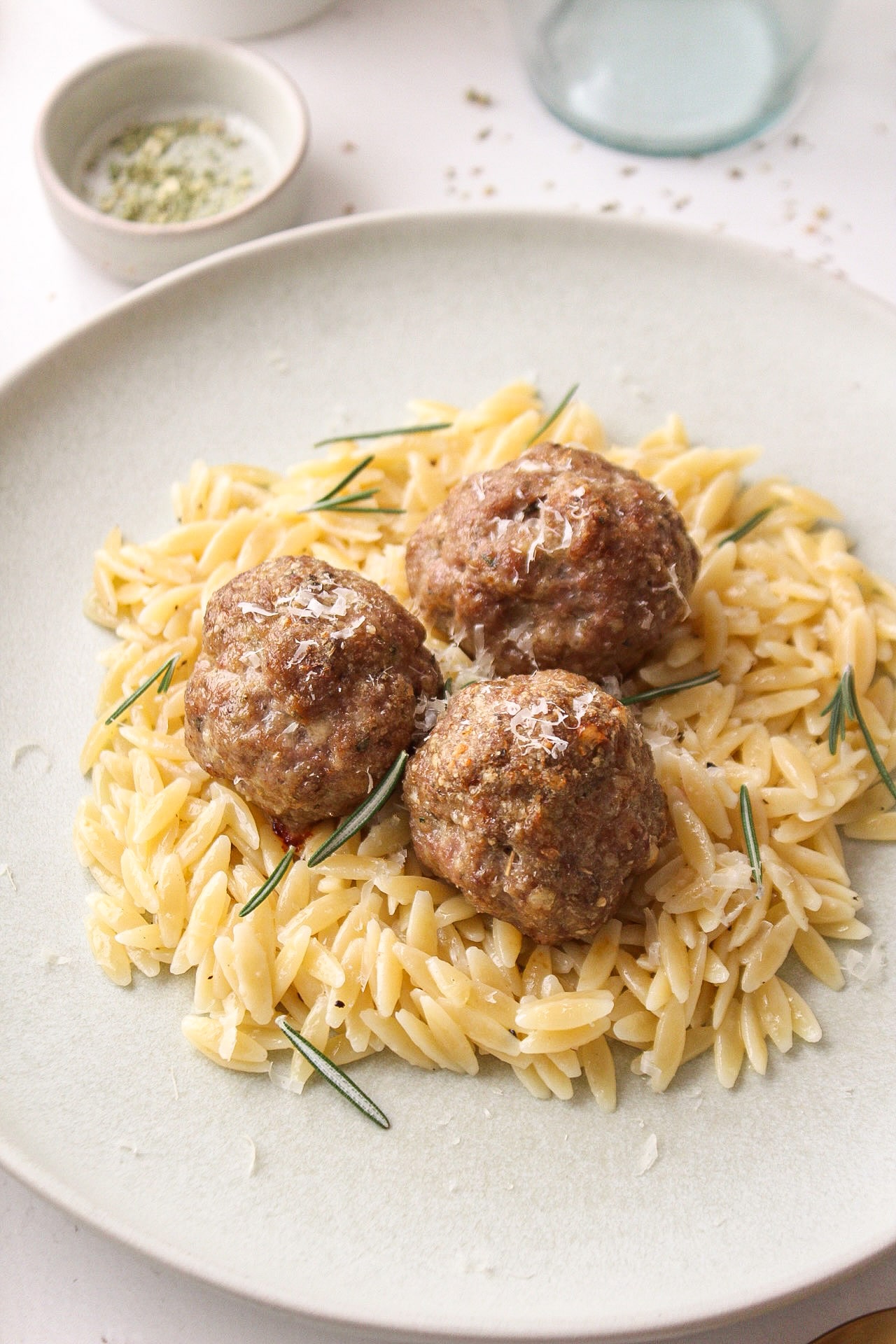 a few meatballs on a bed of orzo