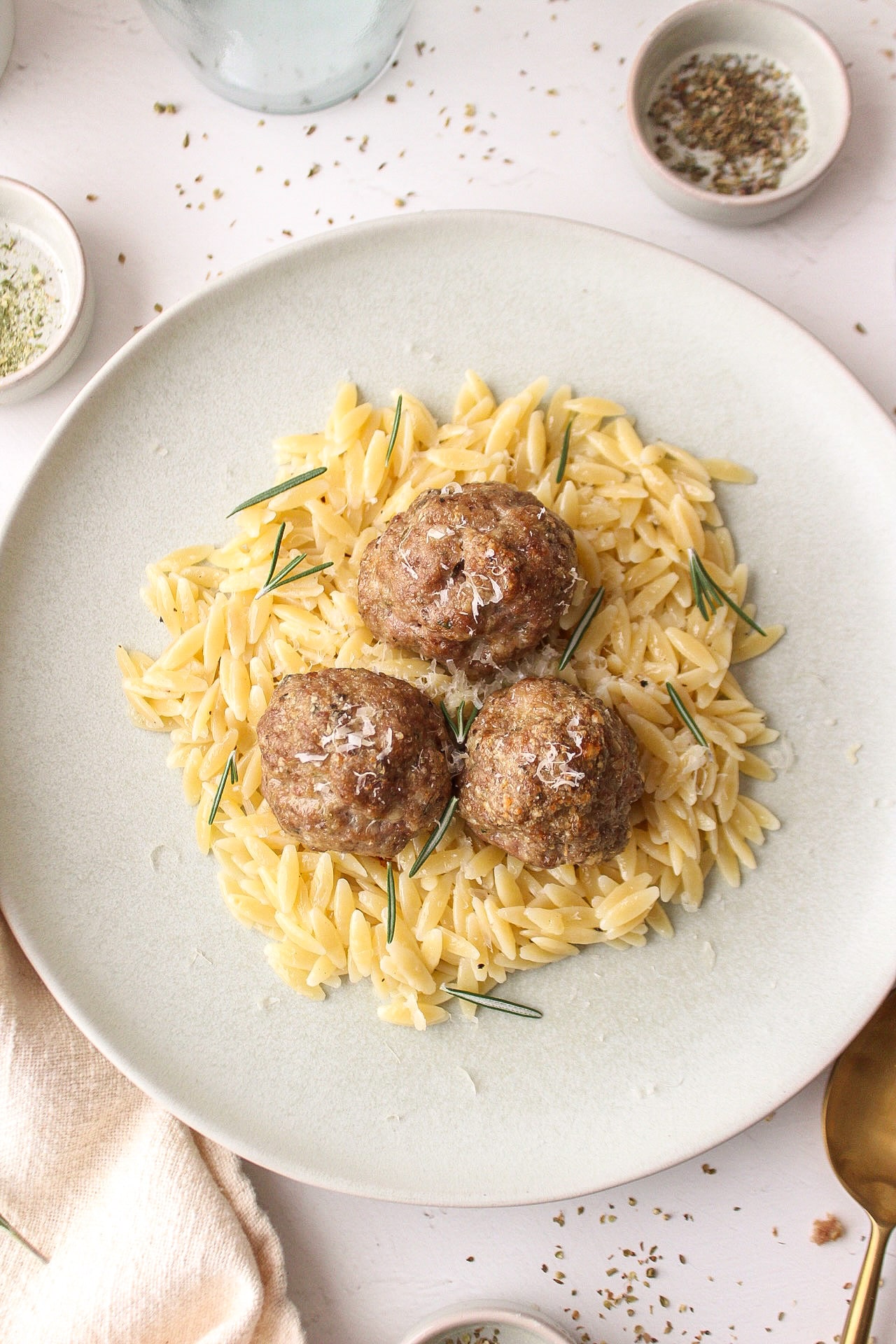 a few meatballs on a bed of orzo on a plate