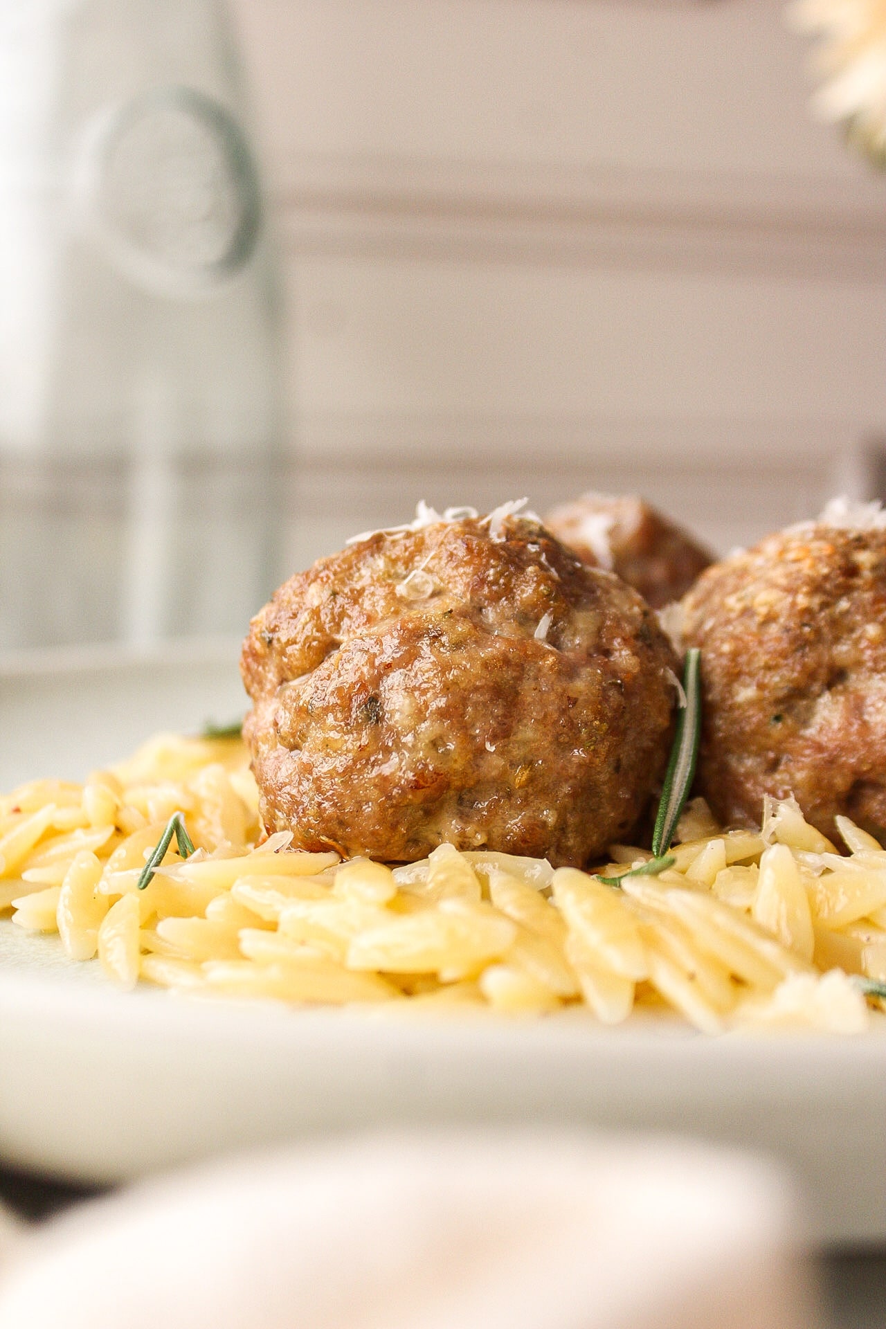 close up of a meatball on a bed of orzo