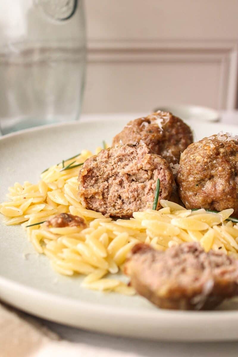 a few meatballs on a bed of orzo