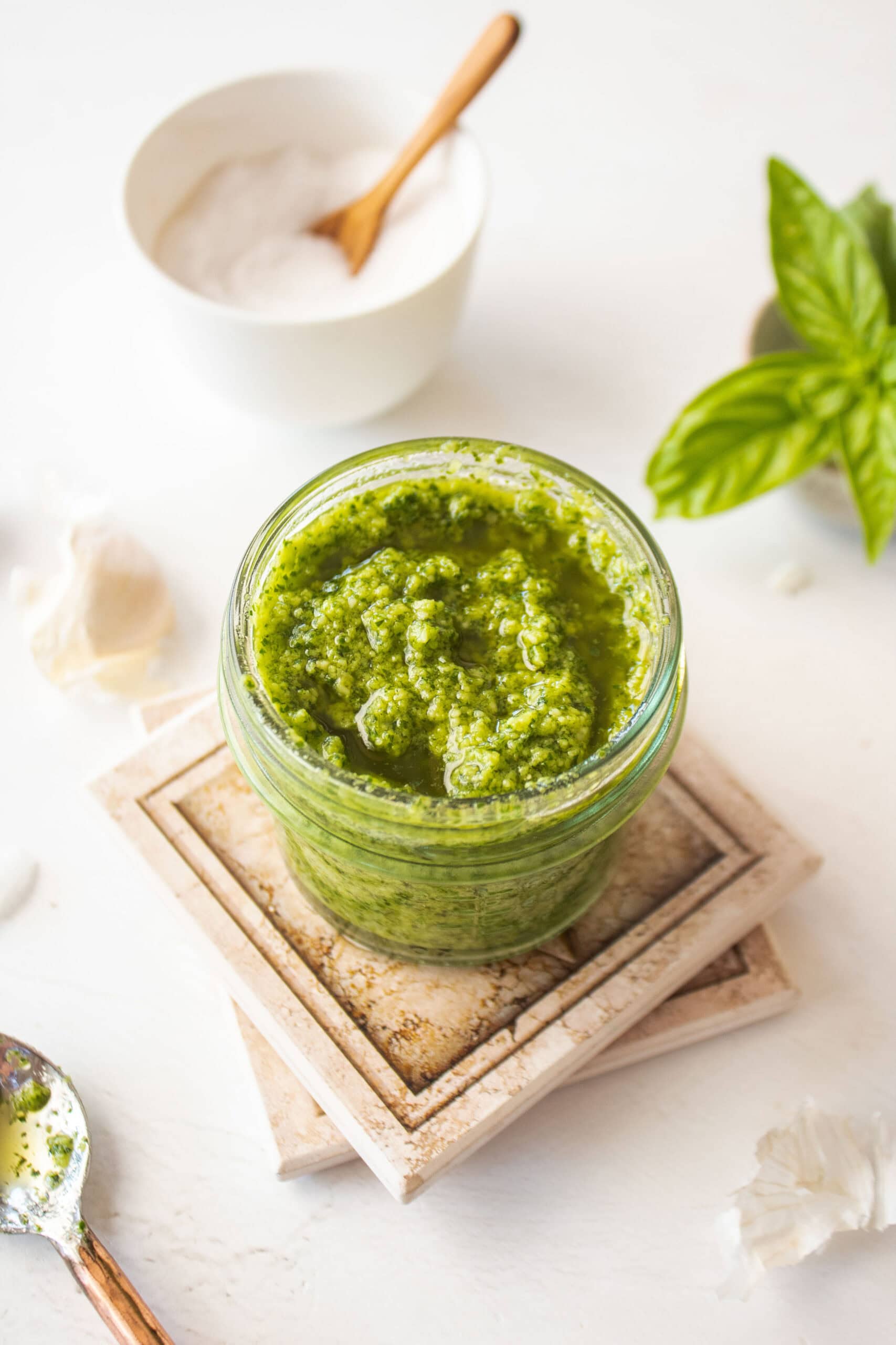 Pesto in a small glass jar on two coaster.