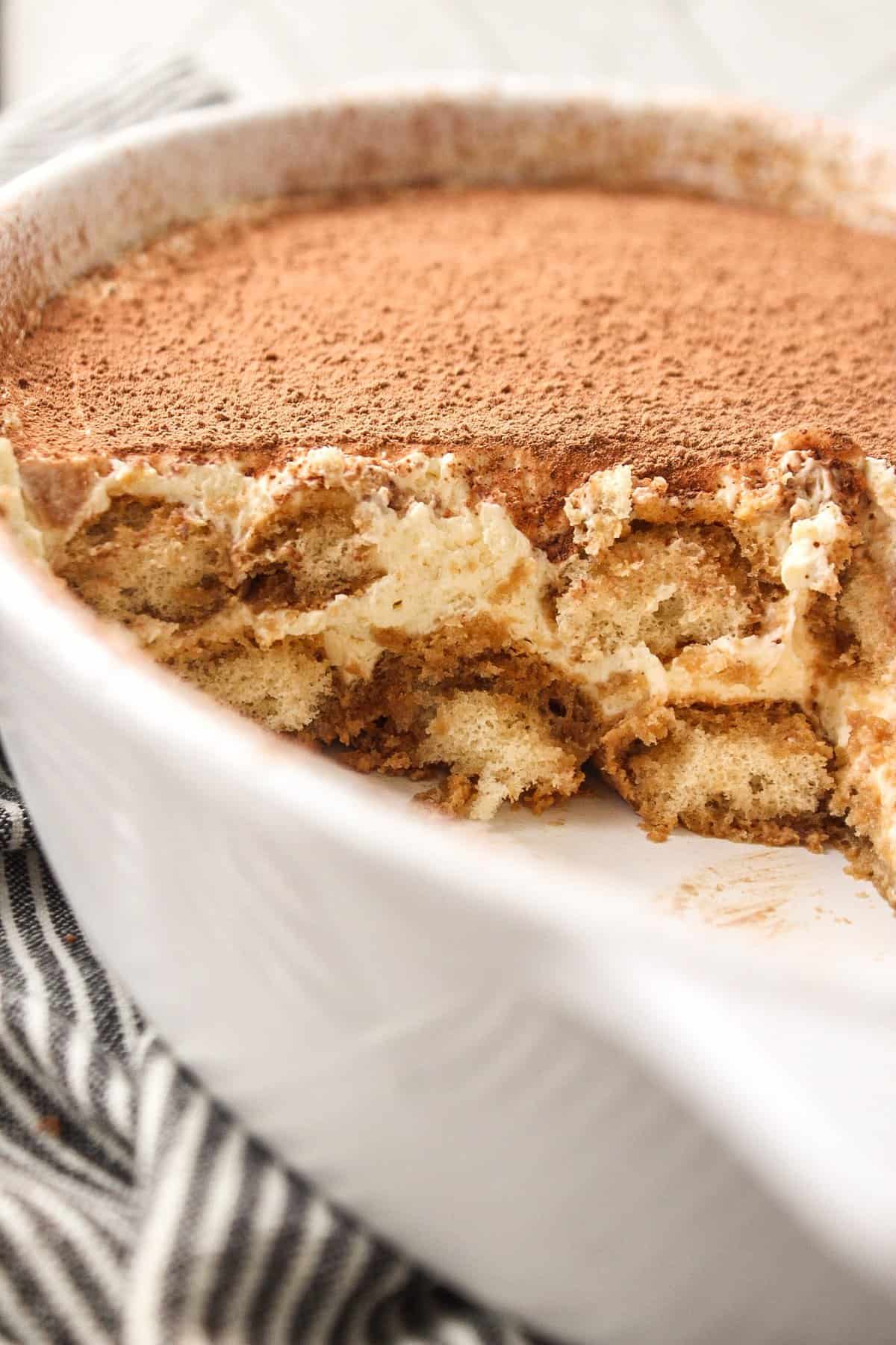 tiramisu in a serving dish with a close up of the layers