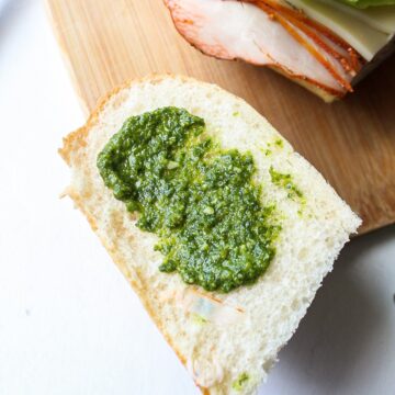 a slice of bread with pesto smeared on top