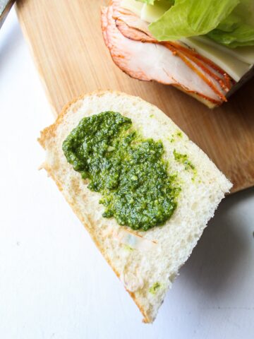 a slice of bread with pesto smeared on top