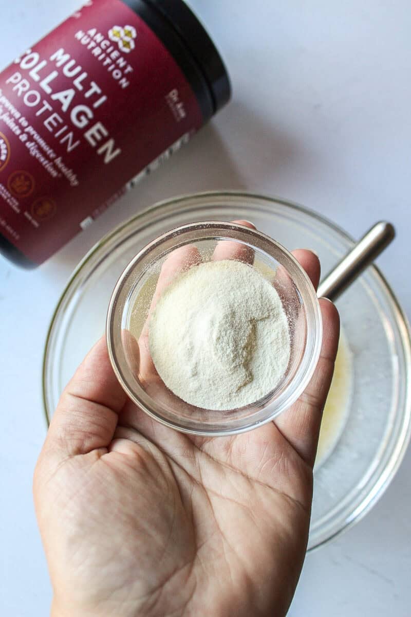 bowl of collagen powder being held over bowl