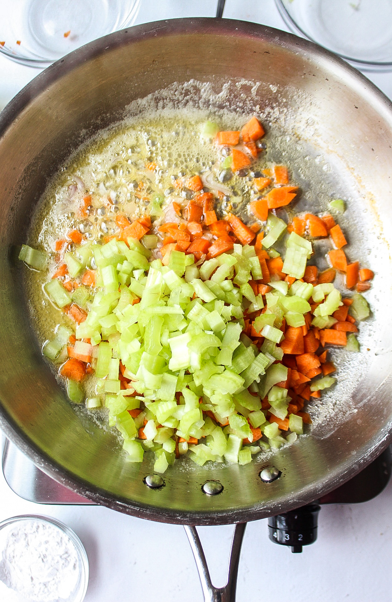 carrots, celery, and onion added to a pan with butter