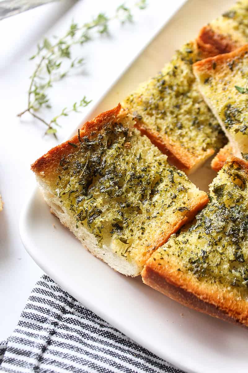 a piece of herbed garlic bread on a plate