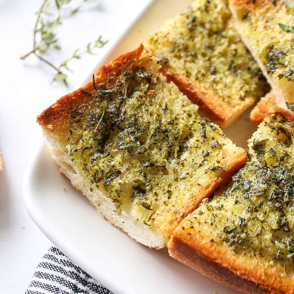 a piece of herbed garlic bread on a plate