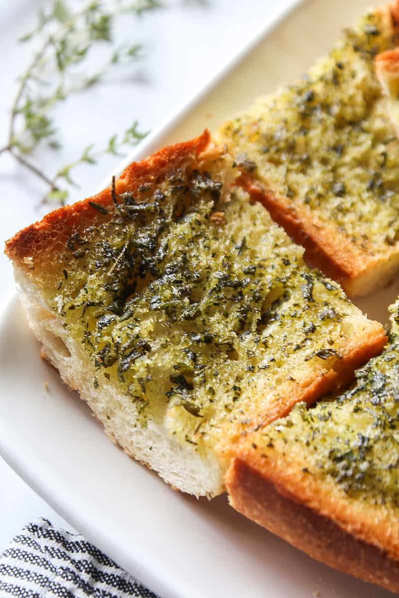 a piece of herbed garlic bread on a plate