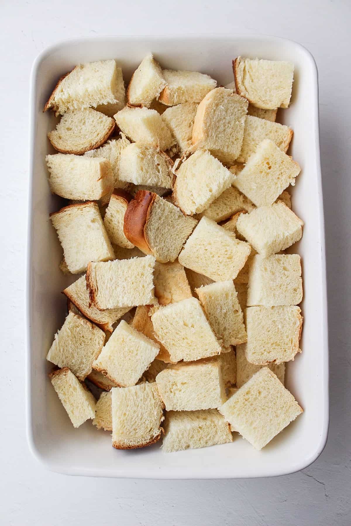 cubed brioche bread in a baking dish