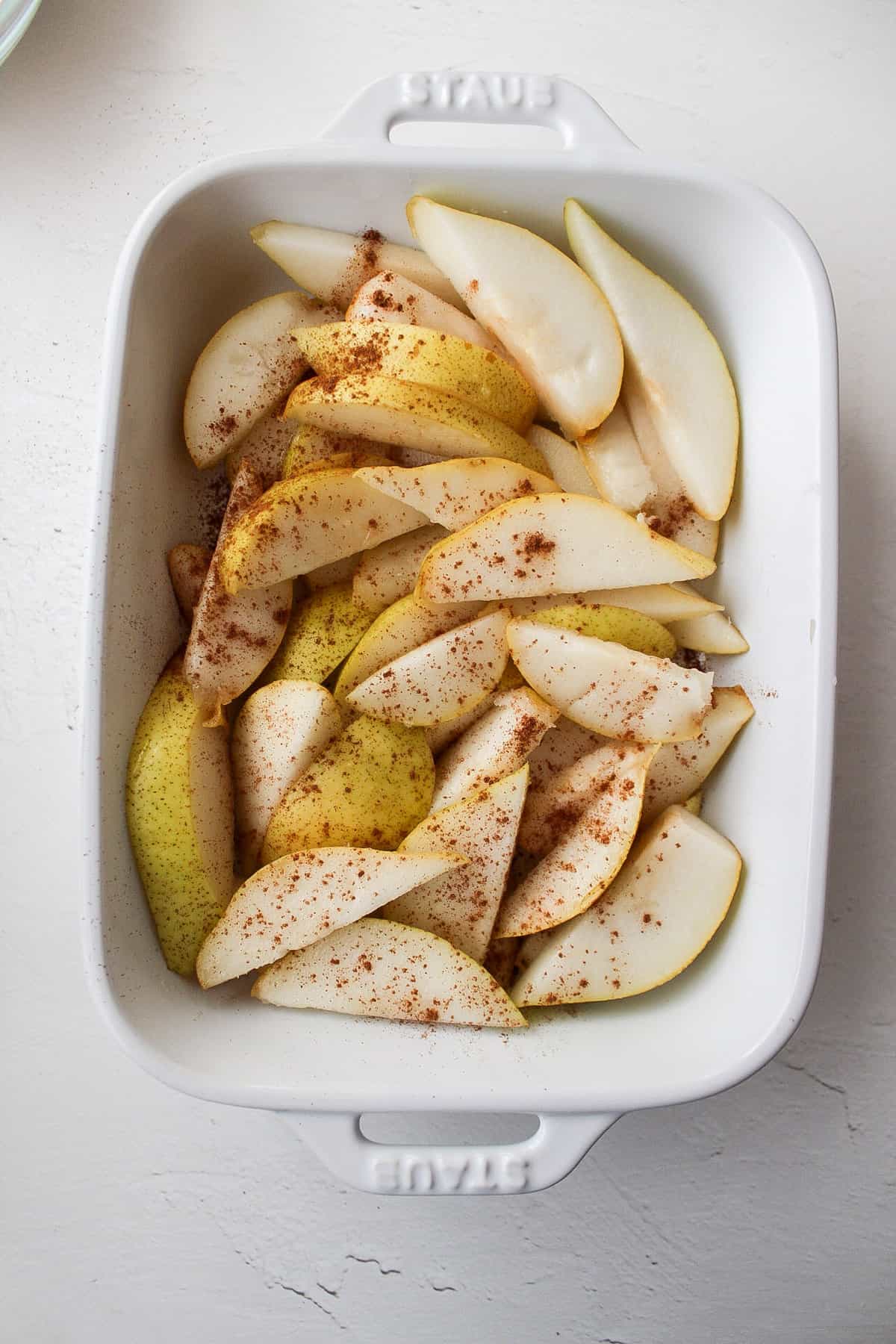 sliced pears in a baking dish with cinnamon