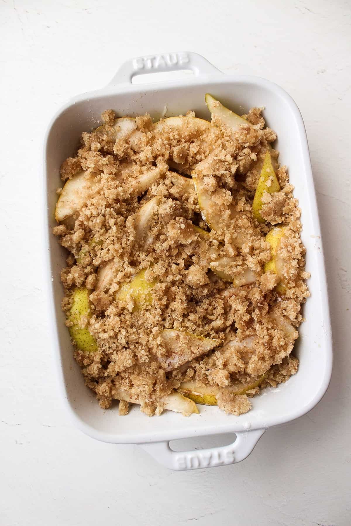 pears coated with a crumble topping in a baking dish