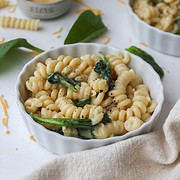 three cheese mac and cheese in a ramekin with spinach and cheese around them