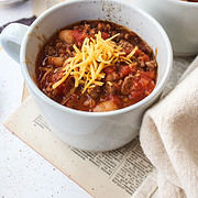 ground beef chili in a mug with cheese on top