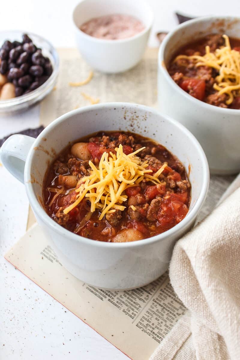 ground beef chili in a mug with cheese on top