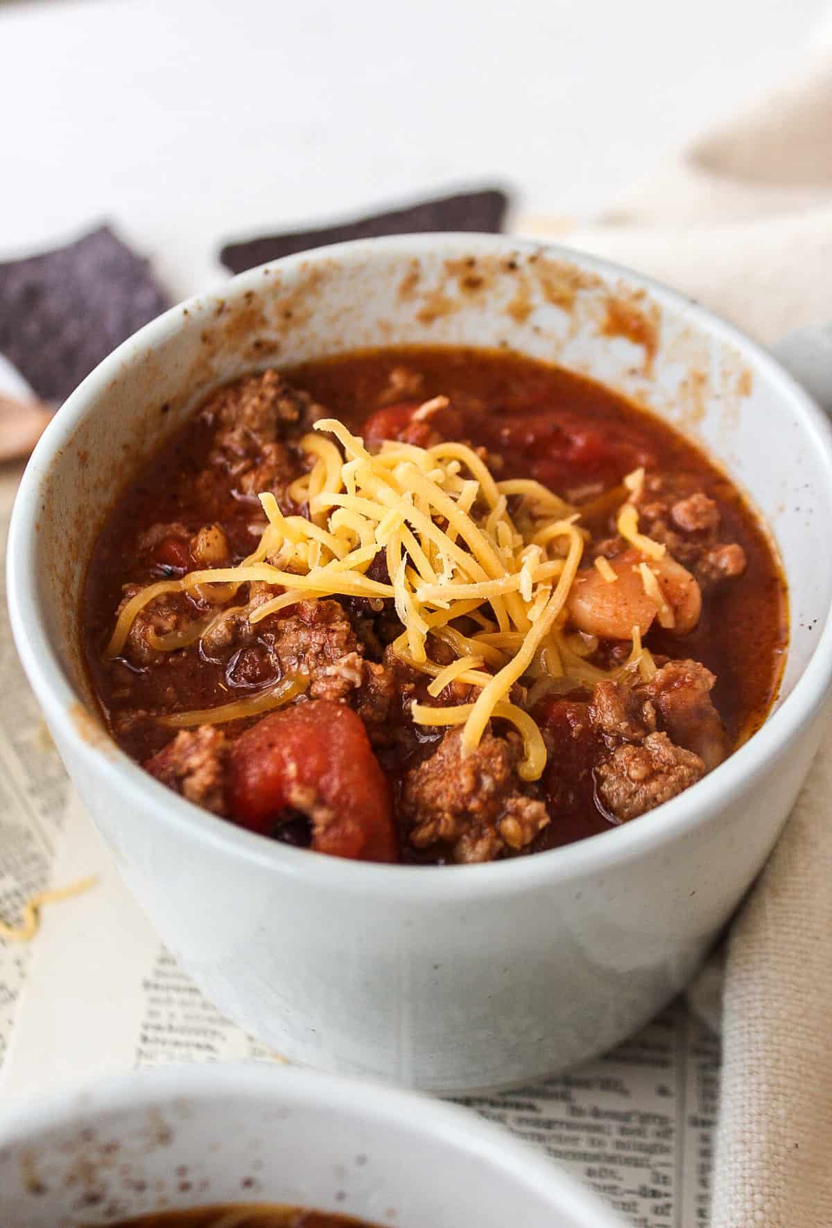ground beef chili in a mug with cheese on top