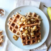 three waffles on a plate topped with pear compote
