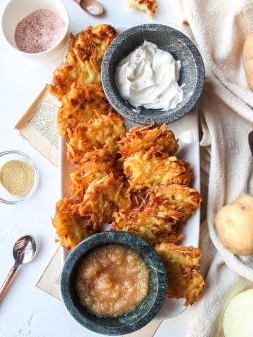 potato latkes on a plate with applesauce and sour cream