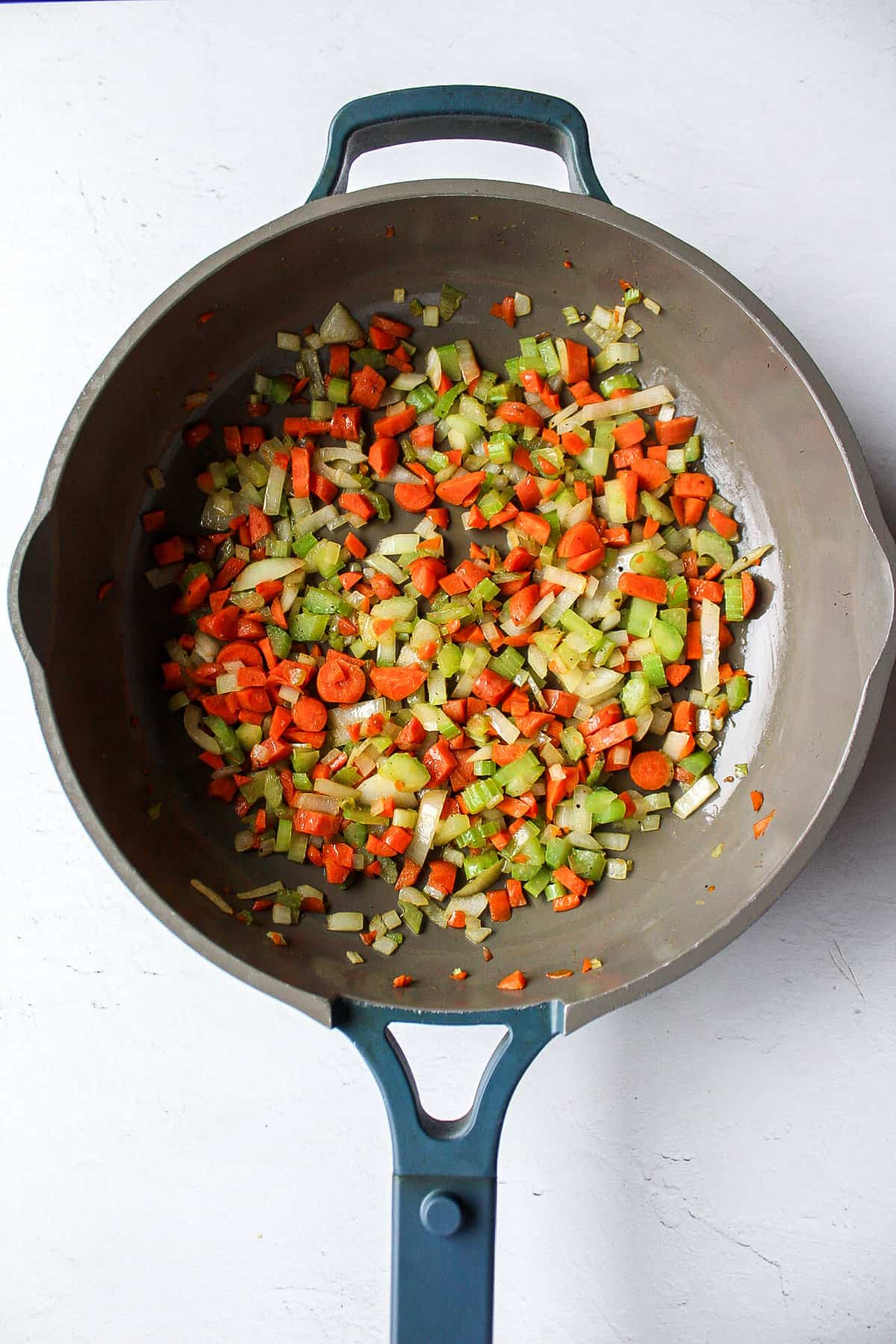 mirepoix of carrot, onion, and celery in a skillet.