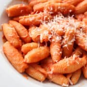 close up of pasta in homemade vodka sauce with fresh parmesan in a bowl.