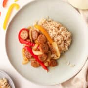 sausage peppers and onions on a plate with rice