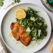 chicken milanese with an arugula salad on a plate
