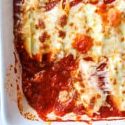 close up of stuffed shells in a casserole dish with two shells missing