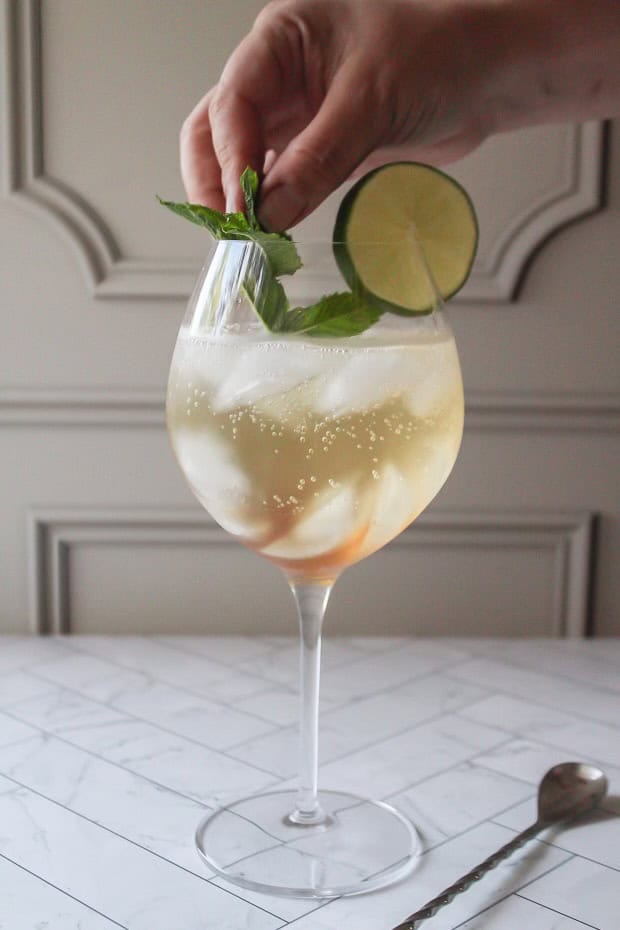 garnishing a glass with mint and lime.