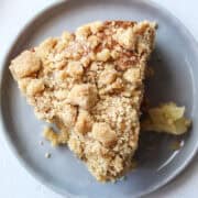 close up of a slice of apple crumb cake on a plate.