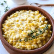 creamed corn with thyme on top in a bowl.