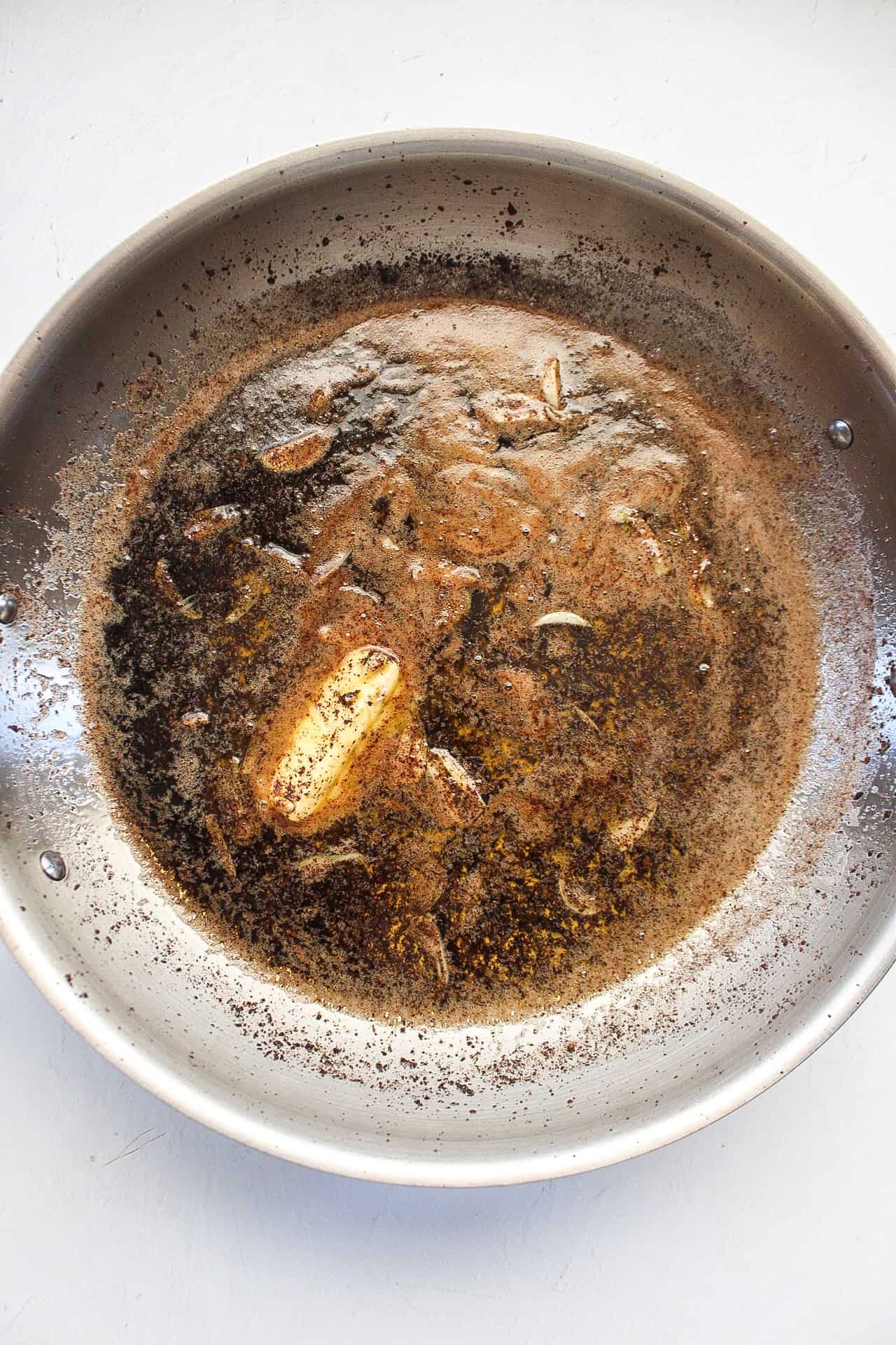 A large skillet with butter, garlic, and lemon making a scampi sauce.