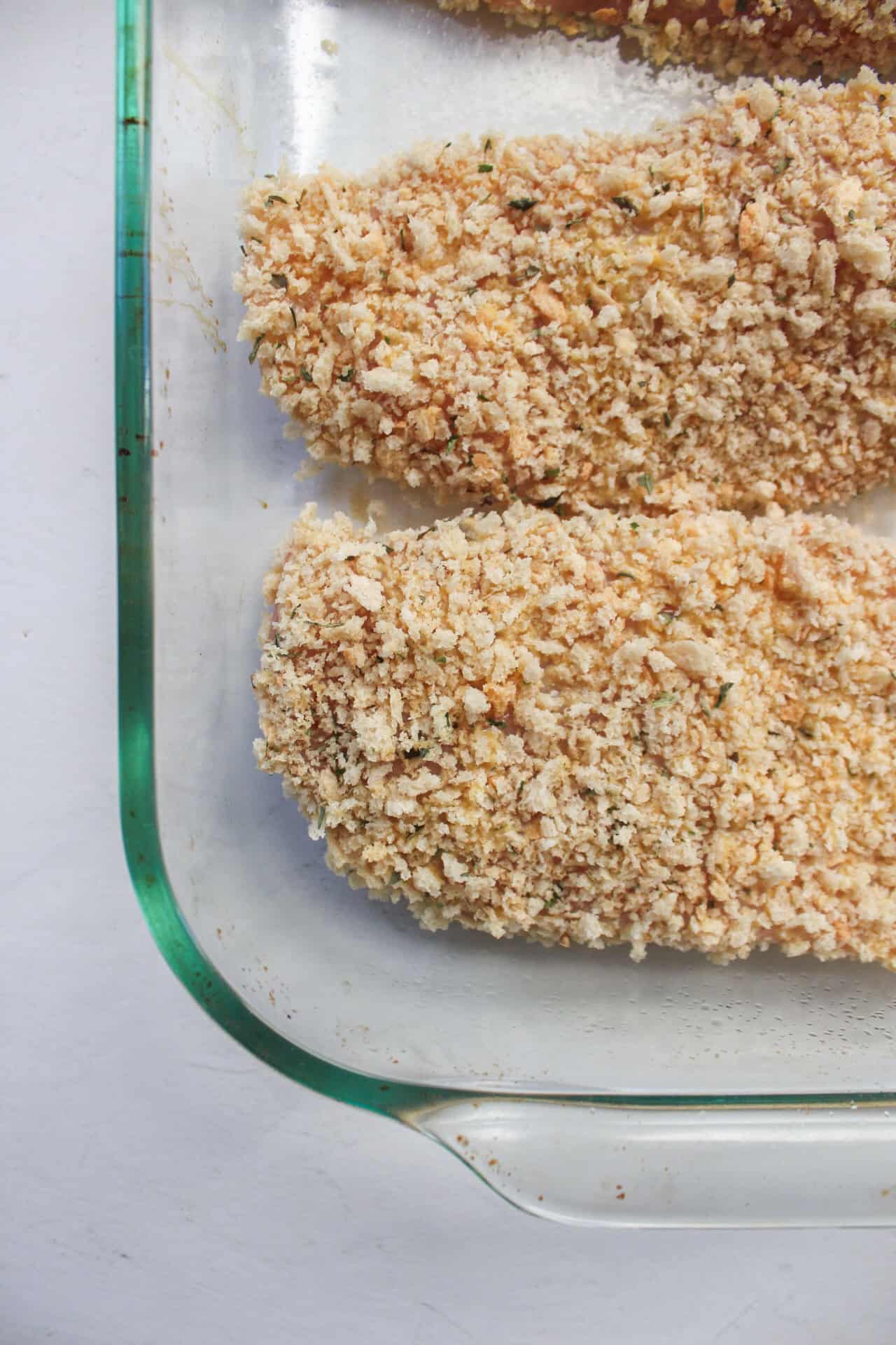 Breaded honey mustard chicken in a baking dish.