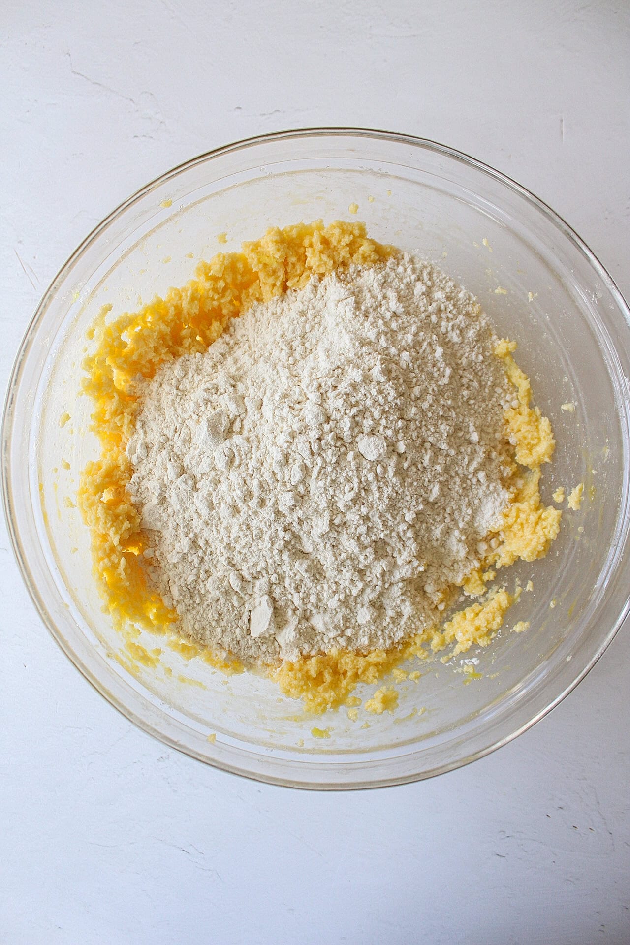 Wet ingredients added to cookie batter in a bowl.