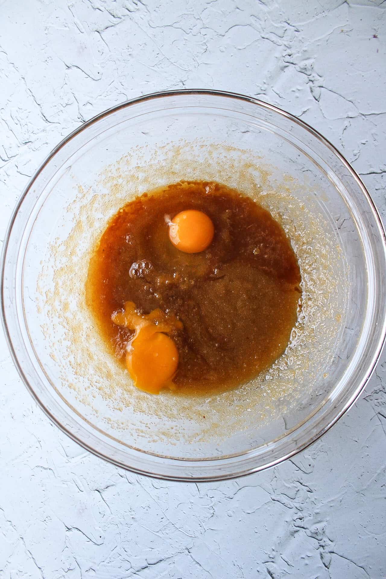 Egg and melted butter mixed together with sugar in a large bowl.